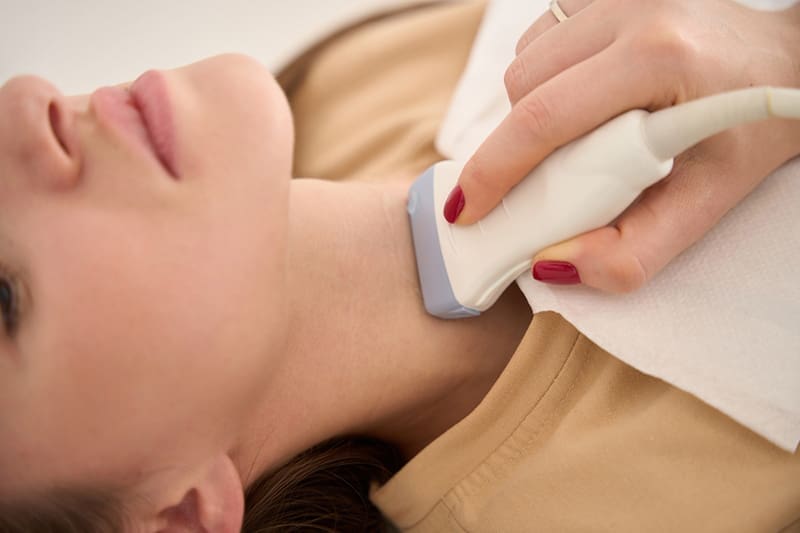 A patient receives an ultrasound of the thyroid