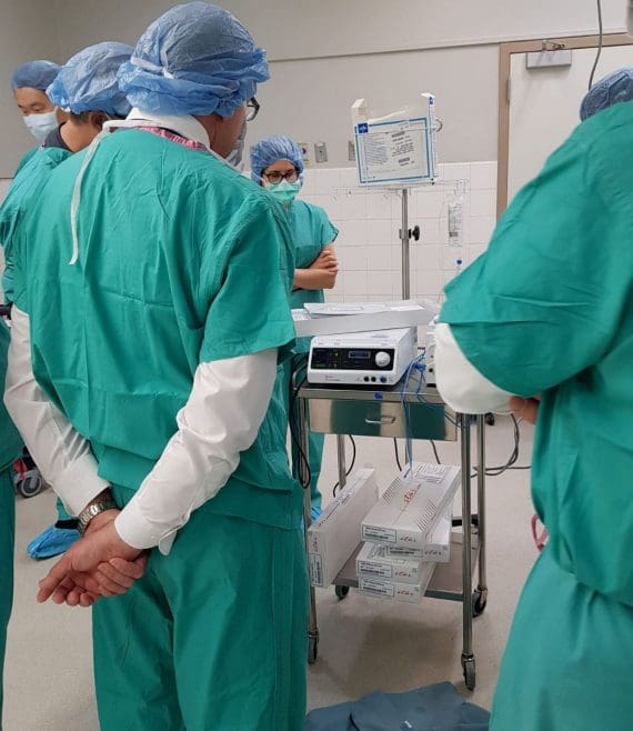 Doctors observe RFA machine in an operating room.