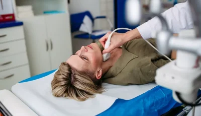 A female patient undergoes a thyroid ultrasound examination.